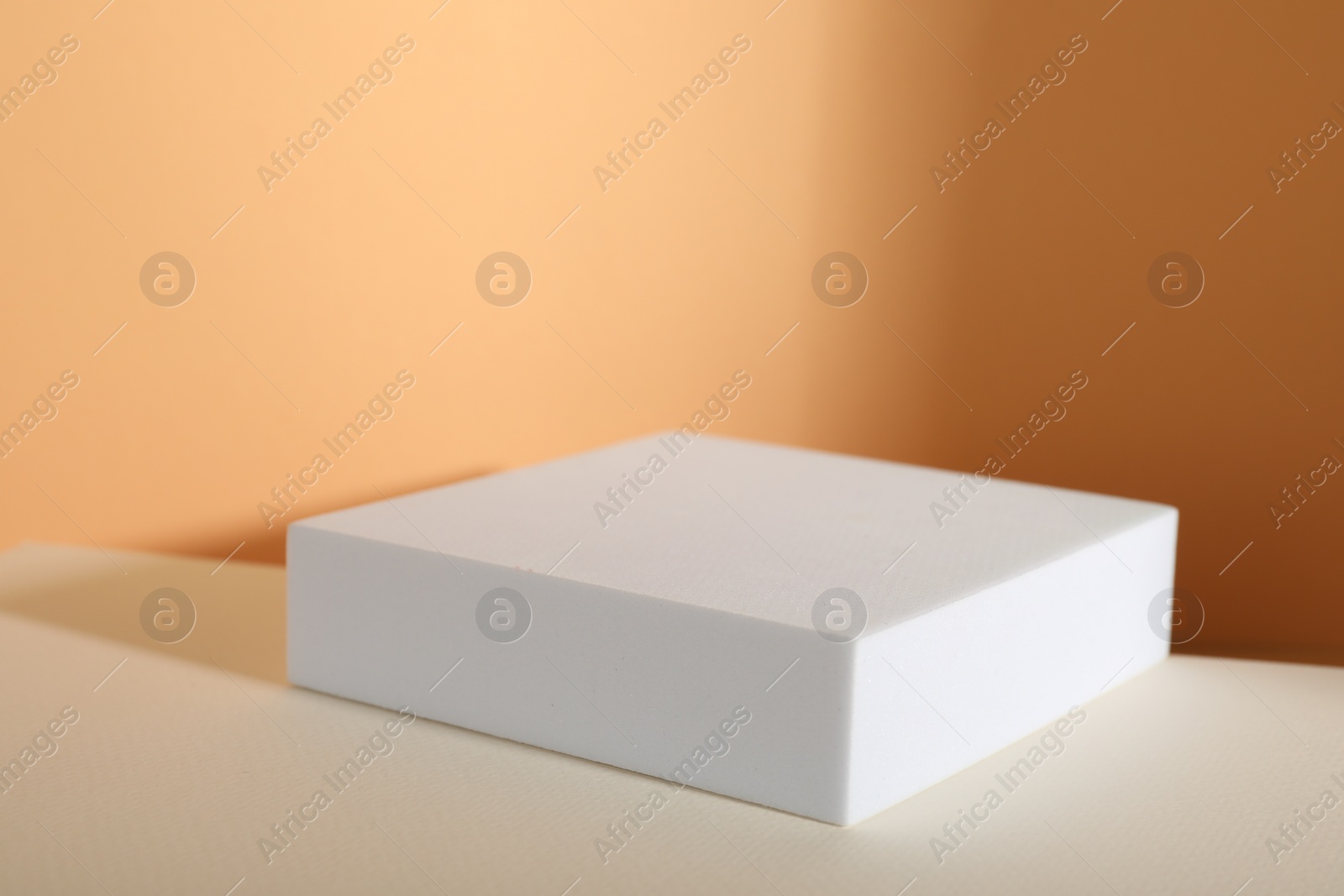 Photo of Presentation of product. Podium and shadows on orange background. Space for text