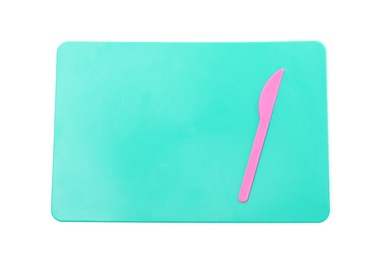 Turquoise board with knife for plasticine on white background, top view