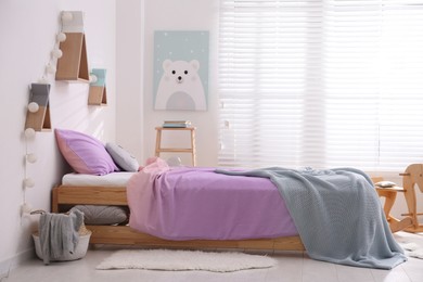 Photo of Comfortable bed with pink linens in children's room