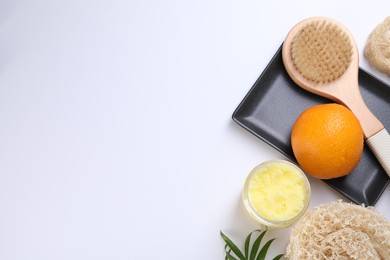 Photo of Orange, scrub and brush on white background, flat lay with space for text. Cellulite treatment