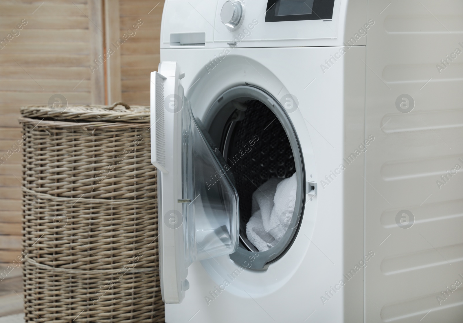 Photo of Washing machine with dirty towel in laundry room, space for text