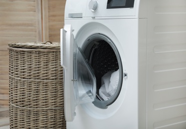 Photo of Washing machine with dirty towel in laundry room, space for text