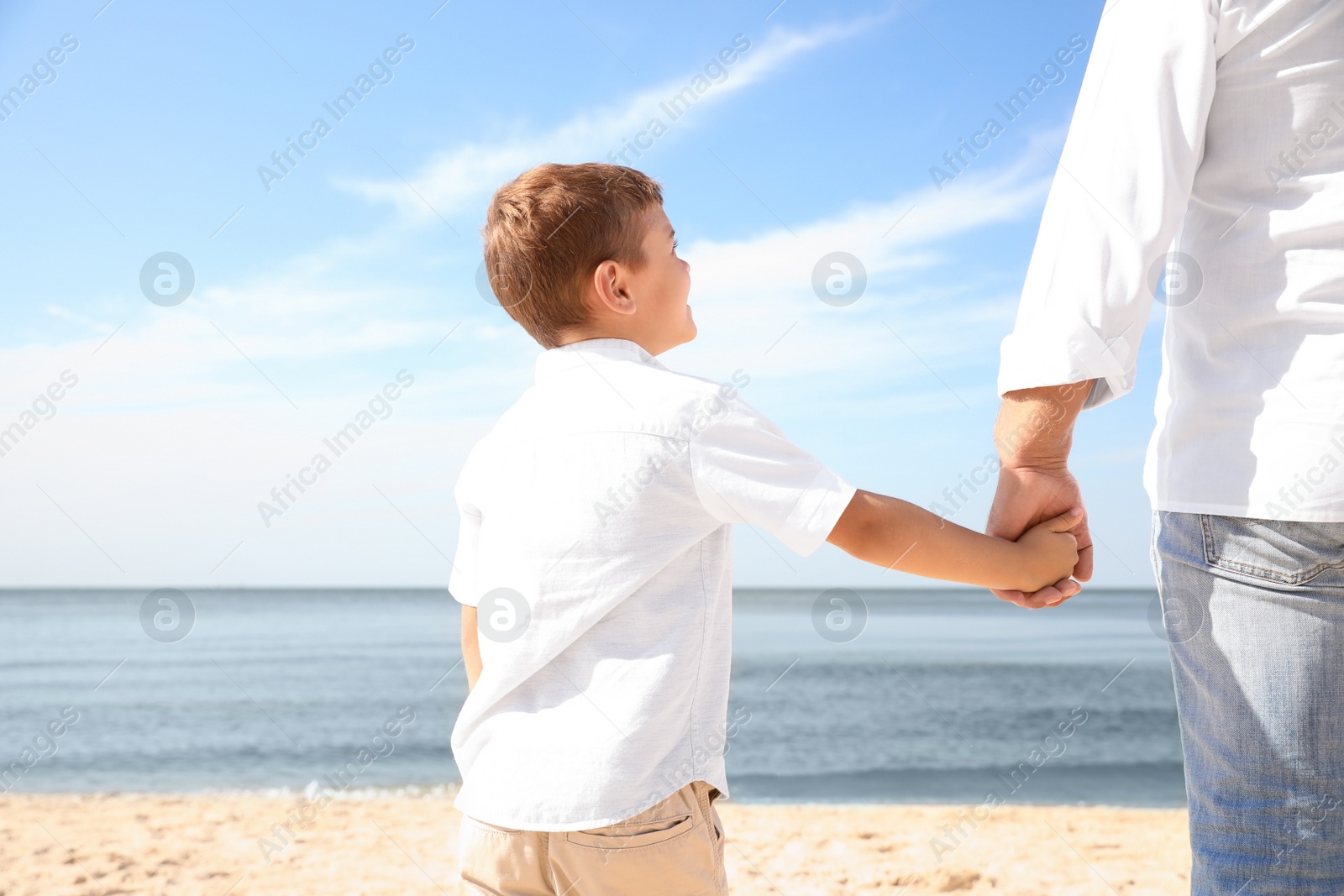 Photo of Little boy with grandfather on sea beach, closeup