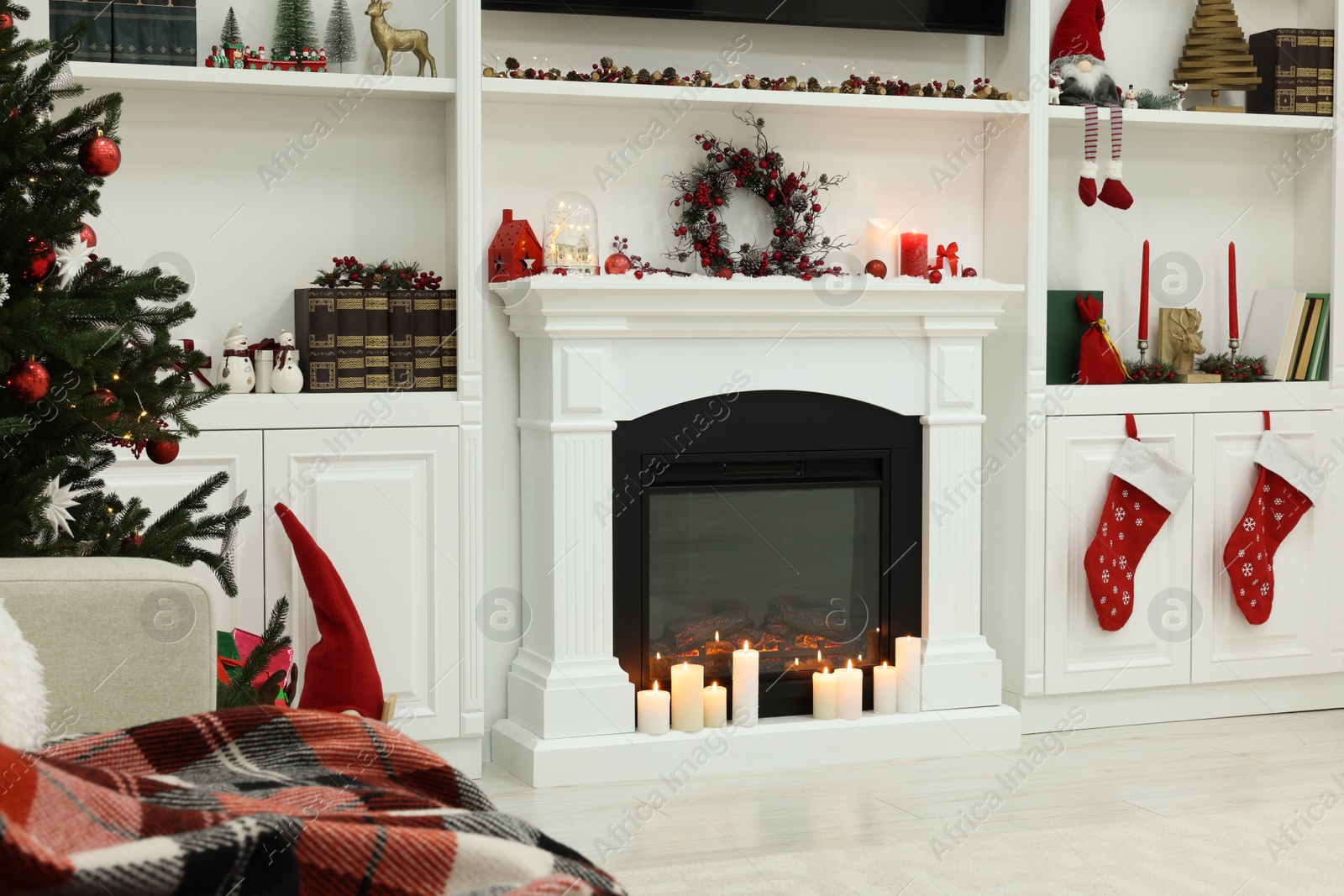 Photo of Cosy room with fireplace and burning candles. Christmas atmosphere