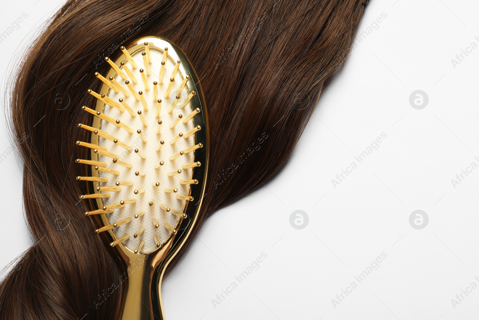 Photo of Stylish brush with brown hair strand on white background, top view