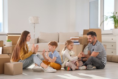 Happy family playing on floor in new apartment. Moving day