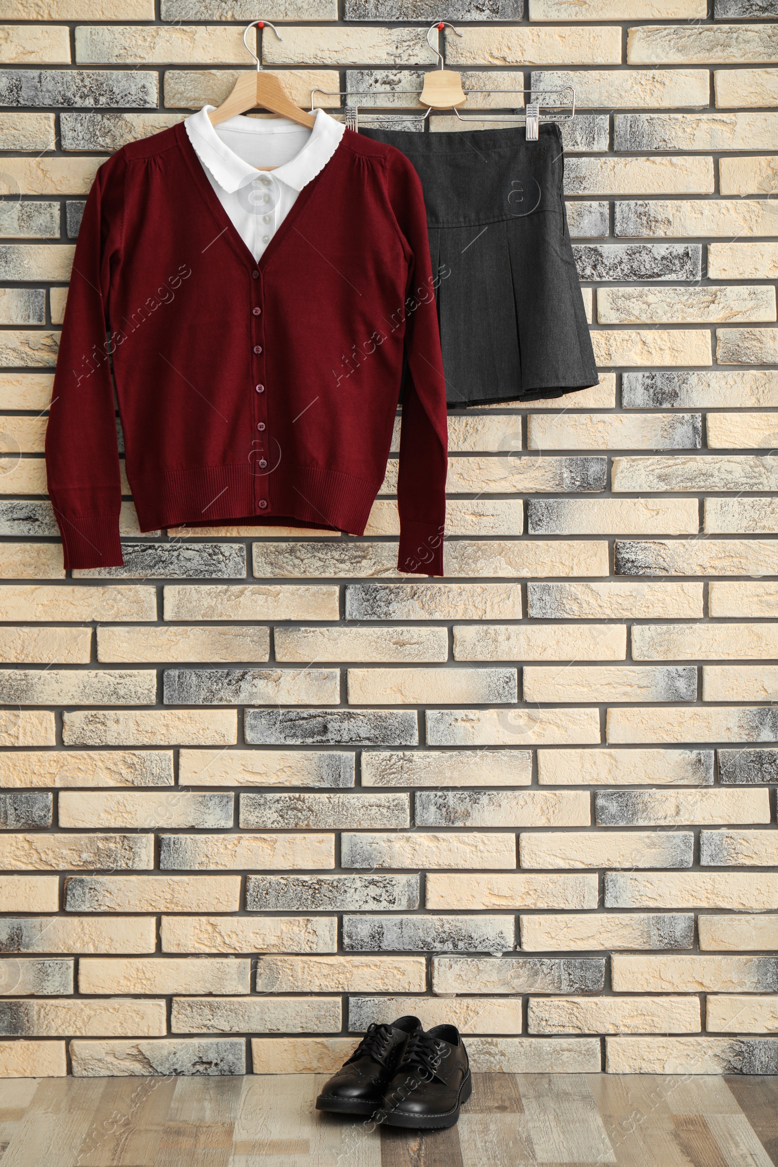 Photo of School uniform for girl hanging on brick wall