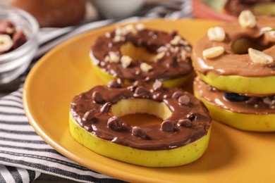 Photo of Fresh apples with nut butters, peanuts and chocolate chips on table, closeup