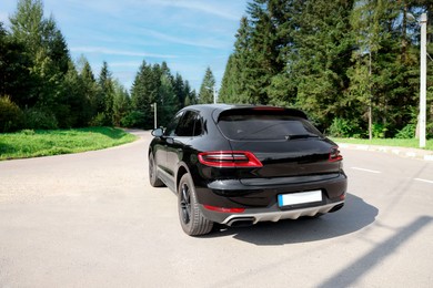 Photo of Picturesque view of modern black car on asphalt road outdoors