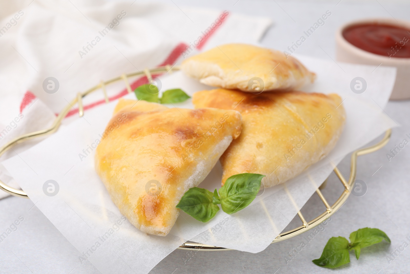 Photo of Delicious samosas and basil on white table