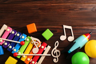 Photo of Baby song concept. Wooden notes, xylophone and toys on table, flat lay. Space for text