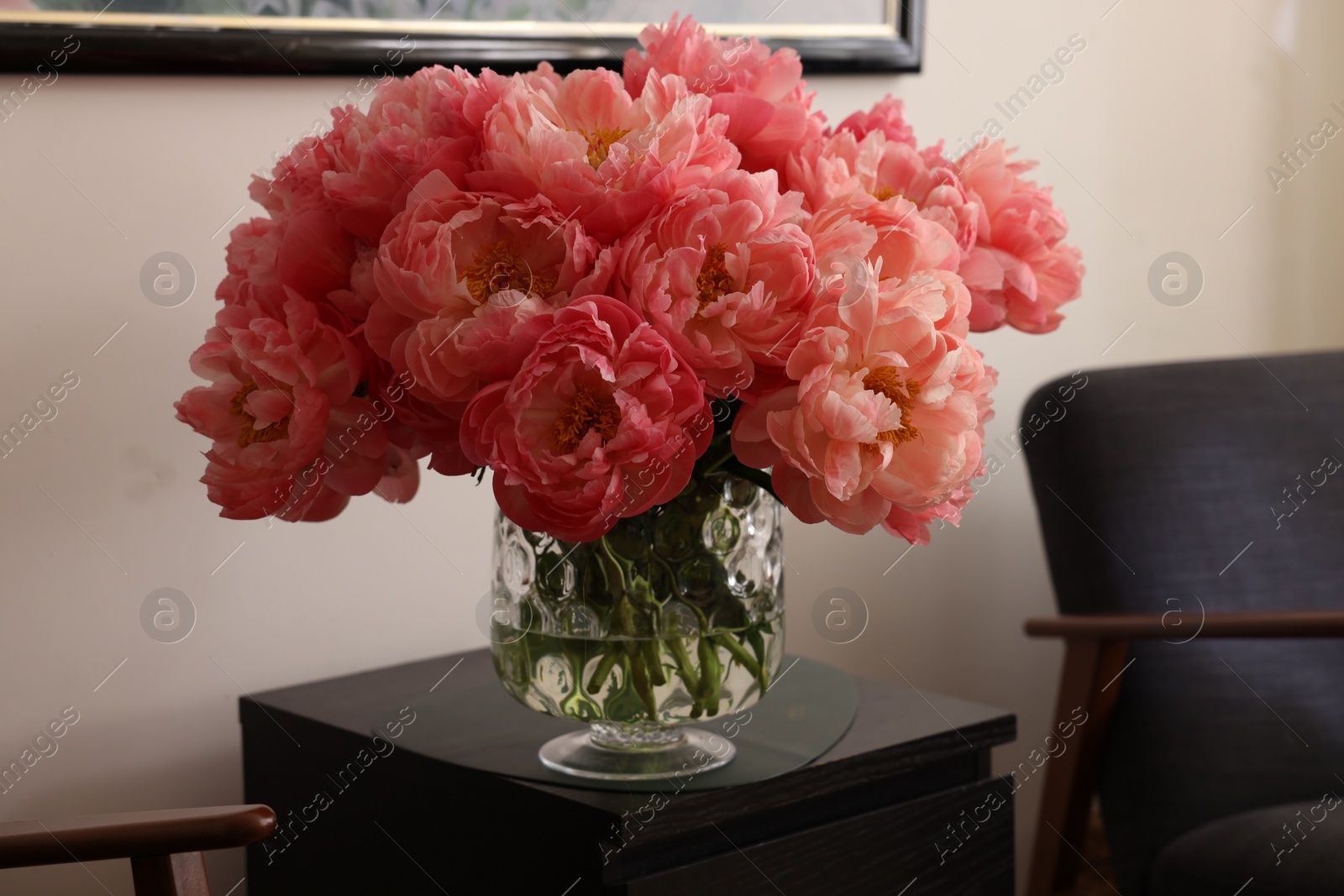 Photo of Beautiful pink peonies in vase on nightstand indoors