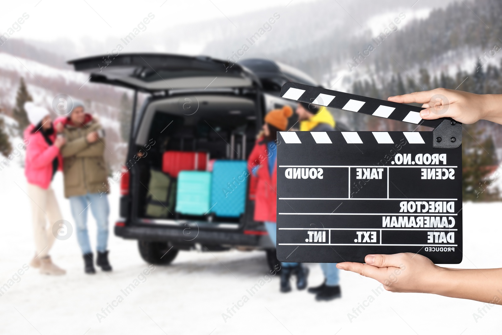 Image of Assistant holding clapperboard and people near car on snowy road, closeup. Cinema production 