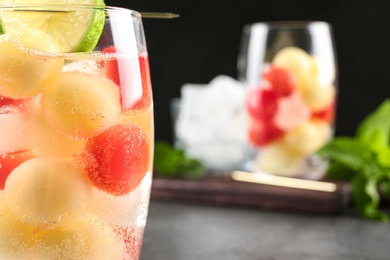 Photo of Glass of melon and watermelon ball cocktail on table, closeup. Space for text