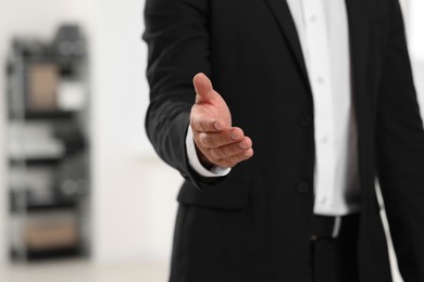 Photo of Man welcoming and offering handshake indoors, closeup. Space for text