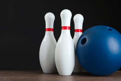Photo of Blue bowling ball and pins on wooden table