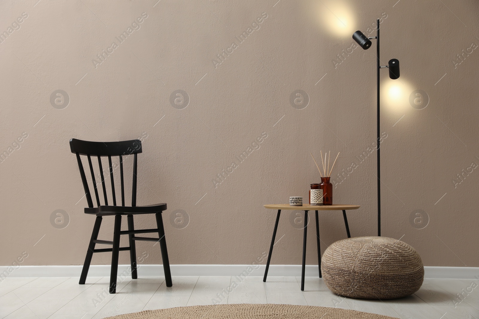 Photo of Stylish room interior with pouf, chair and decor elements