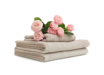 Photo of Stack of clean folded towels with flowers on white background