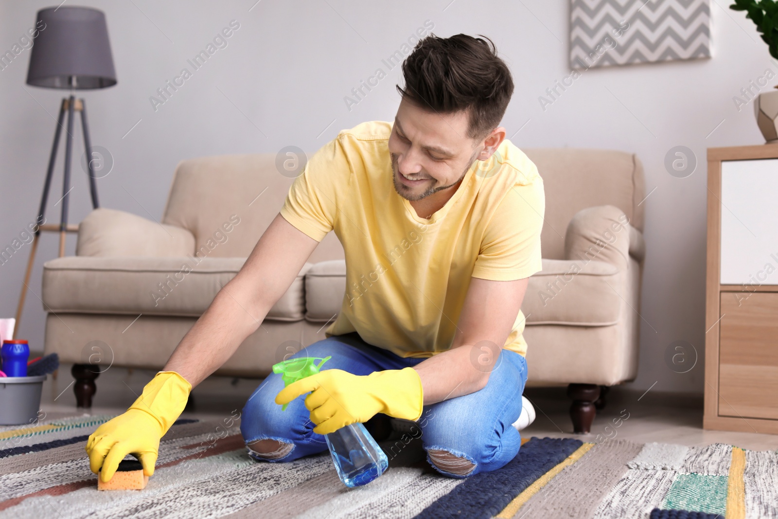 Photo of Mature man cleaning carpet at home