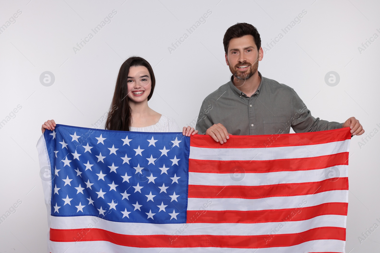 Photo of 4th of July - Independence Day of USA. Happy father and his daughter with American flag on white background