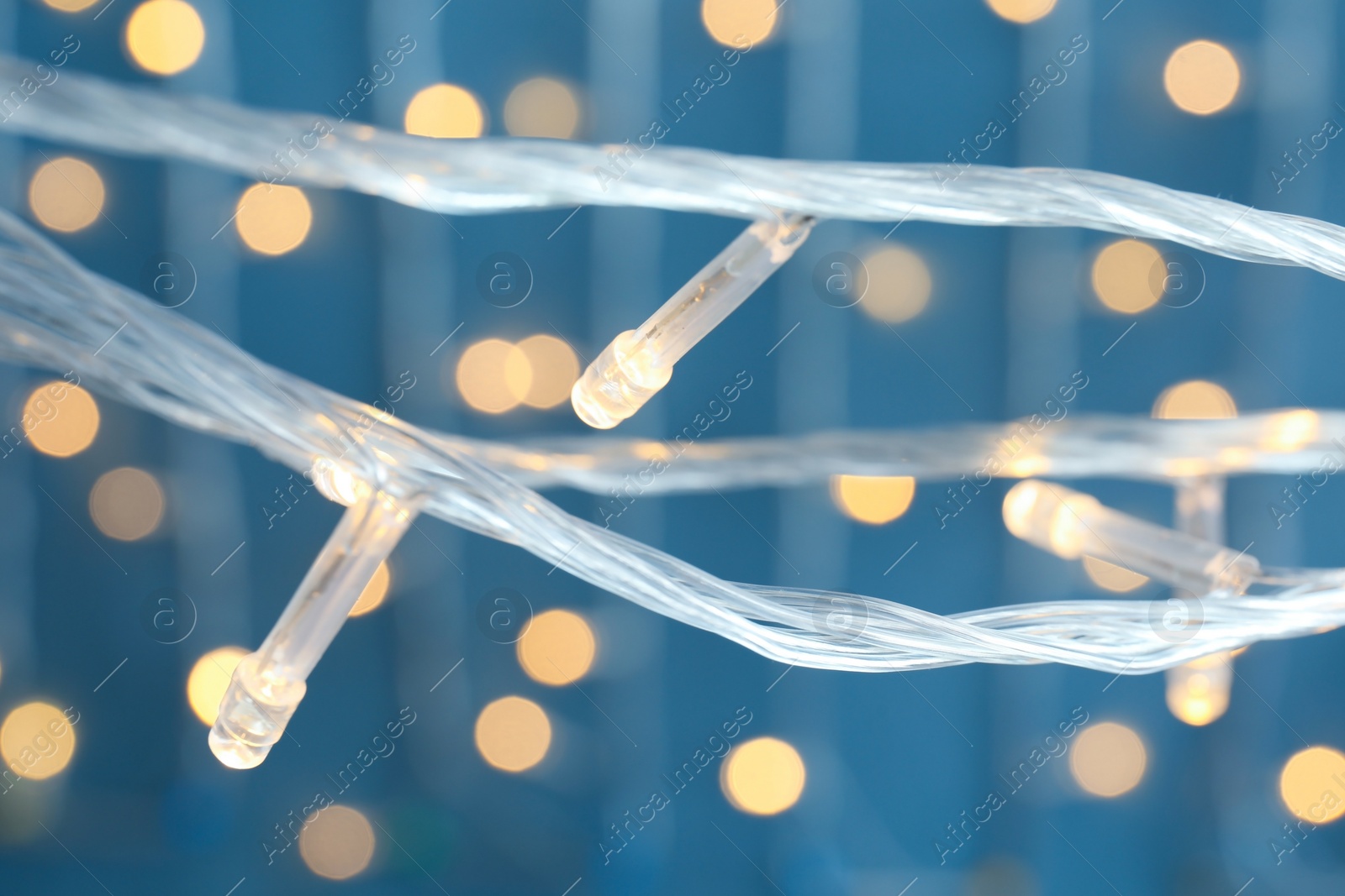 Photo of Beautiful Christmas lights on color background, closeup