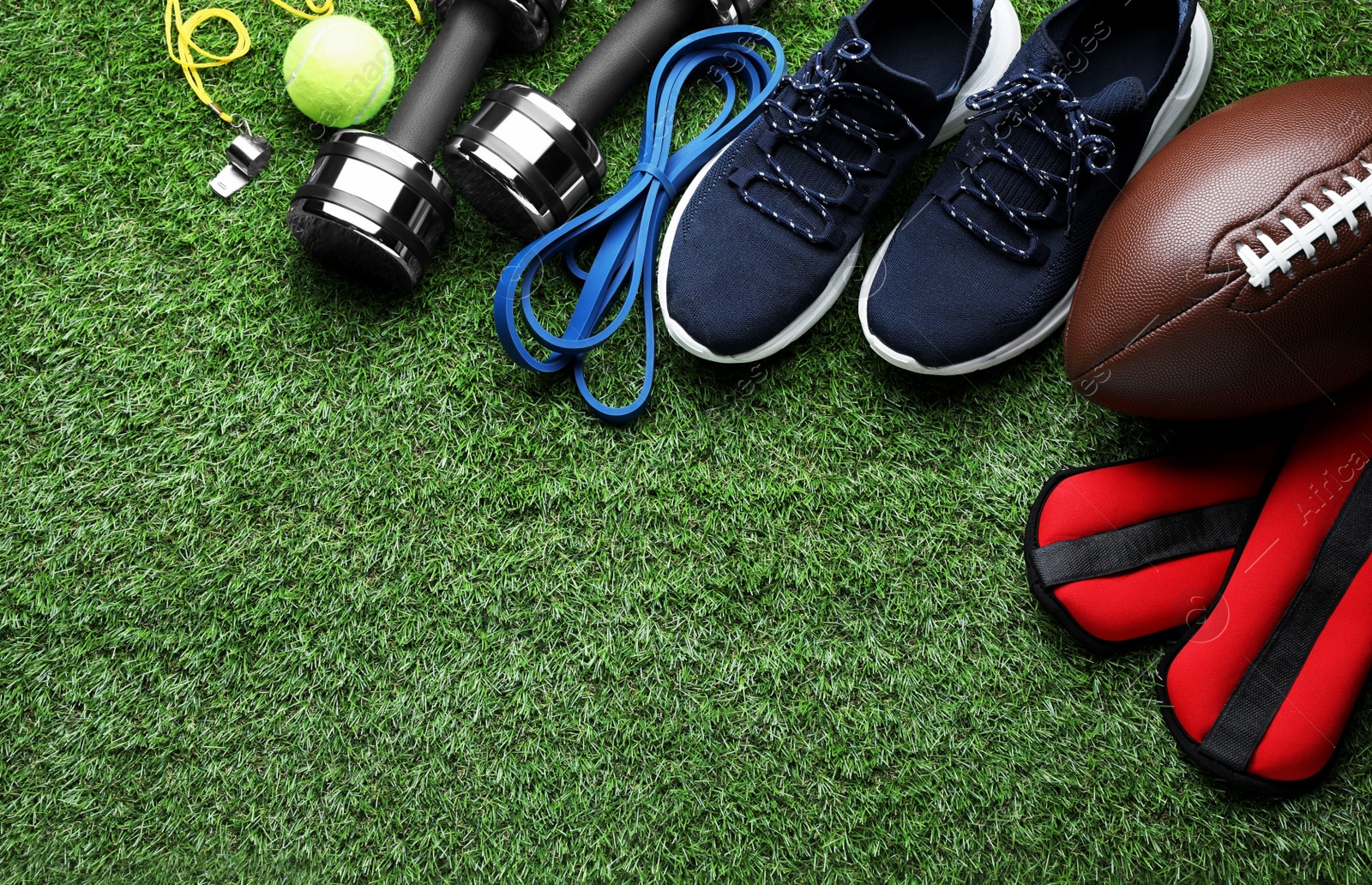 Photo of Set of different colorful sports equipment on green grass, flat lay. Space for text