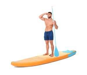 Photo of Happy man with paddle on orange SUP board against white background