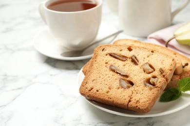 Photo of Slices of pear bread on white marble table, closeup. Homemade cake