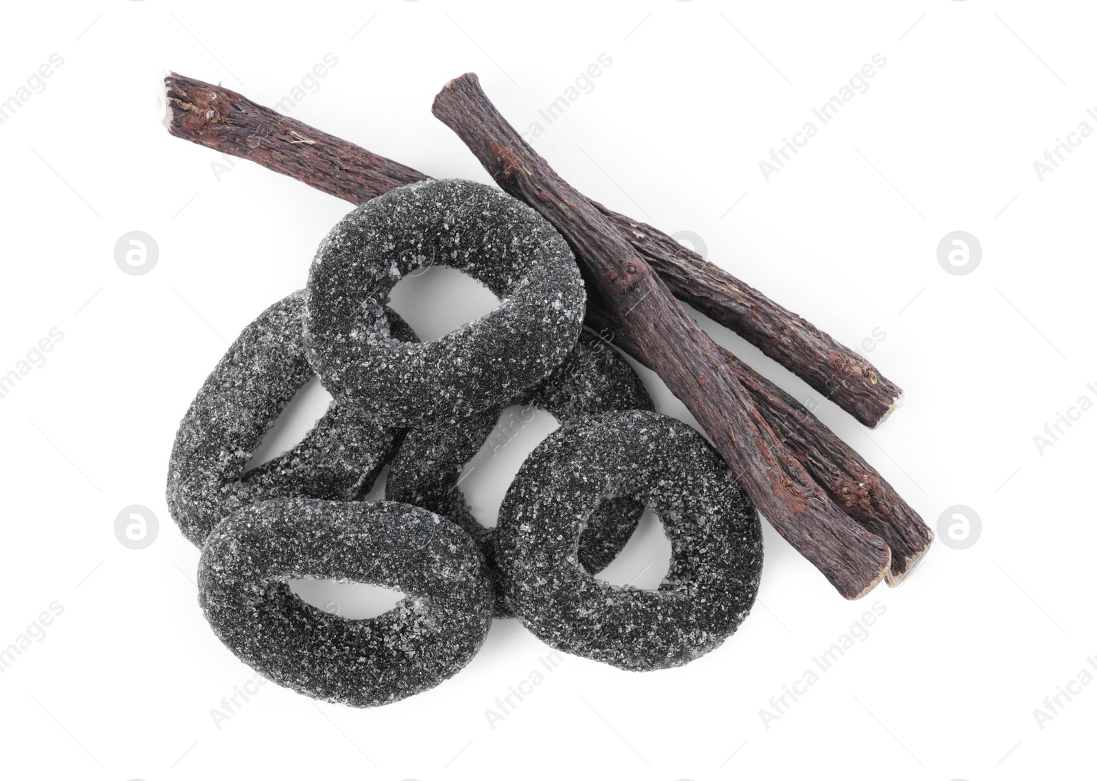 Photo of Many tasty candies and dried sticks of liquorice root isolated on white, top view