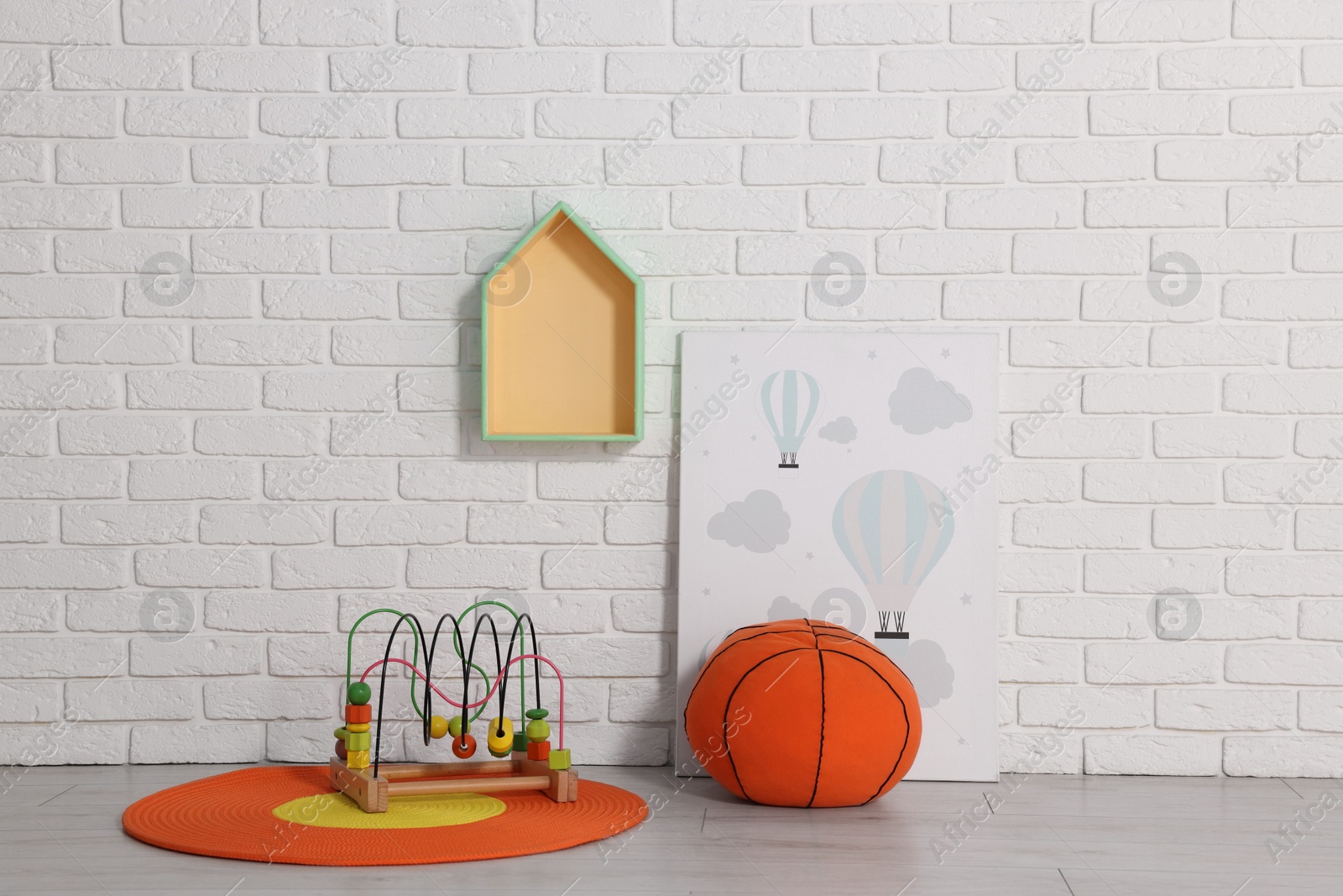 Photo of Beautiful children's room with white brick wall and toys. Interior design