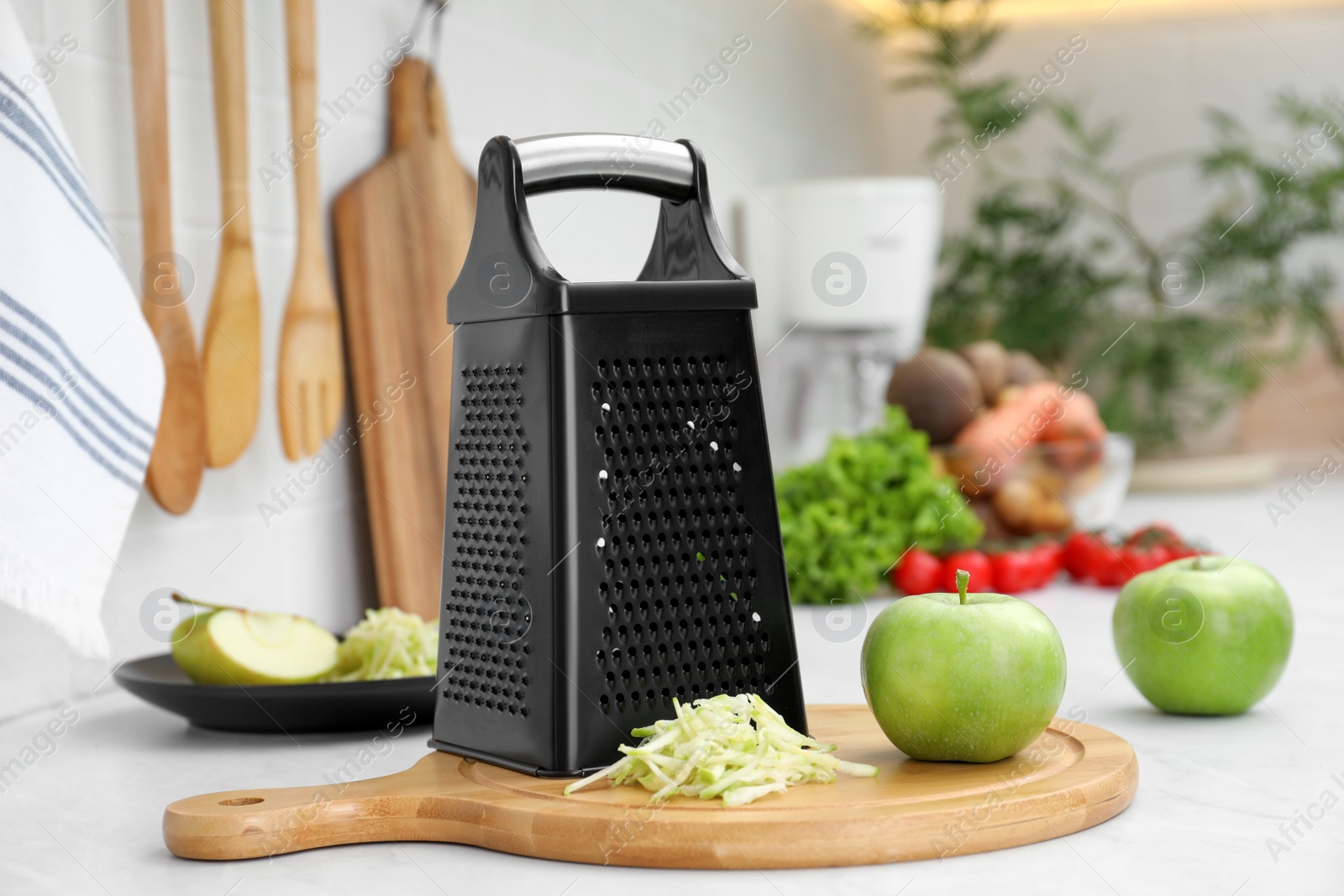 Photo of Grater and fresh ripe apples on kitchen counter