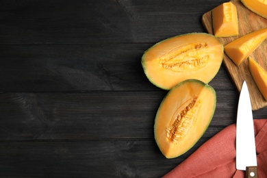 Photo of Tasty fresh cut melon on black wooden table, flat lay. Space for text