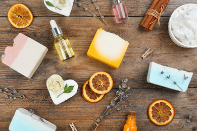 Photo of Flat lay composition with natural handmade soap and ingredients on wooden table