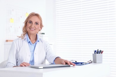 Photo of Doctor with laptop at workplace in clinic. Online medicine concept