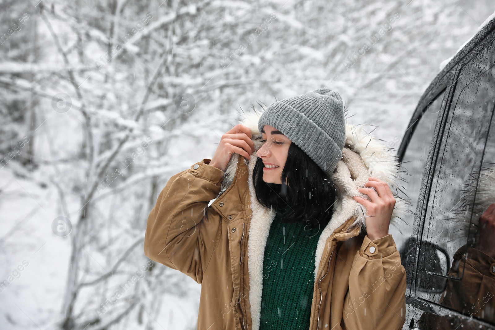 Photo of Young woman wearing warm clothes outdoors on snowy day. Winter vacation