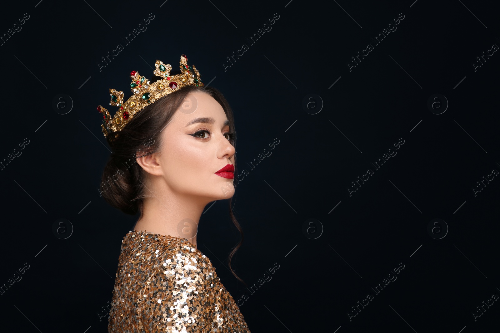 Photo of Beautiful young woman wearing luxurious crown on black background, space for text