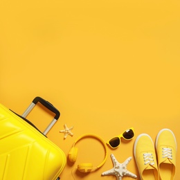 Flat lay composition with suitcase on color background, space for text. Beach accessories