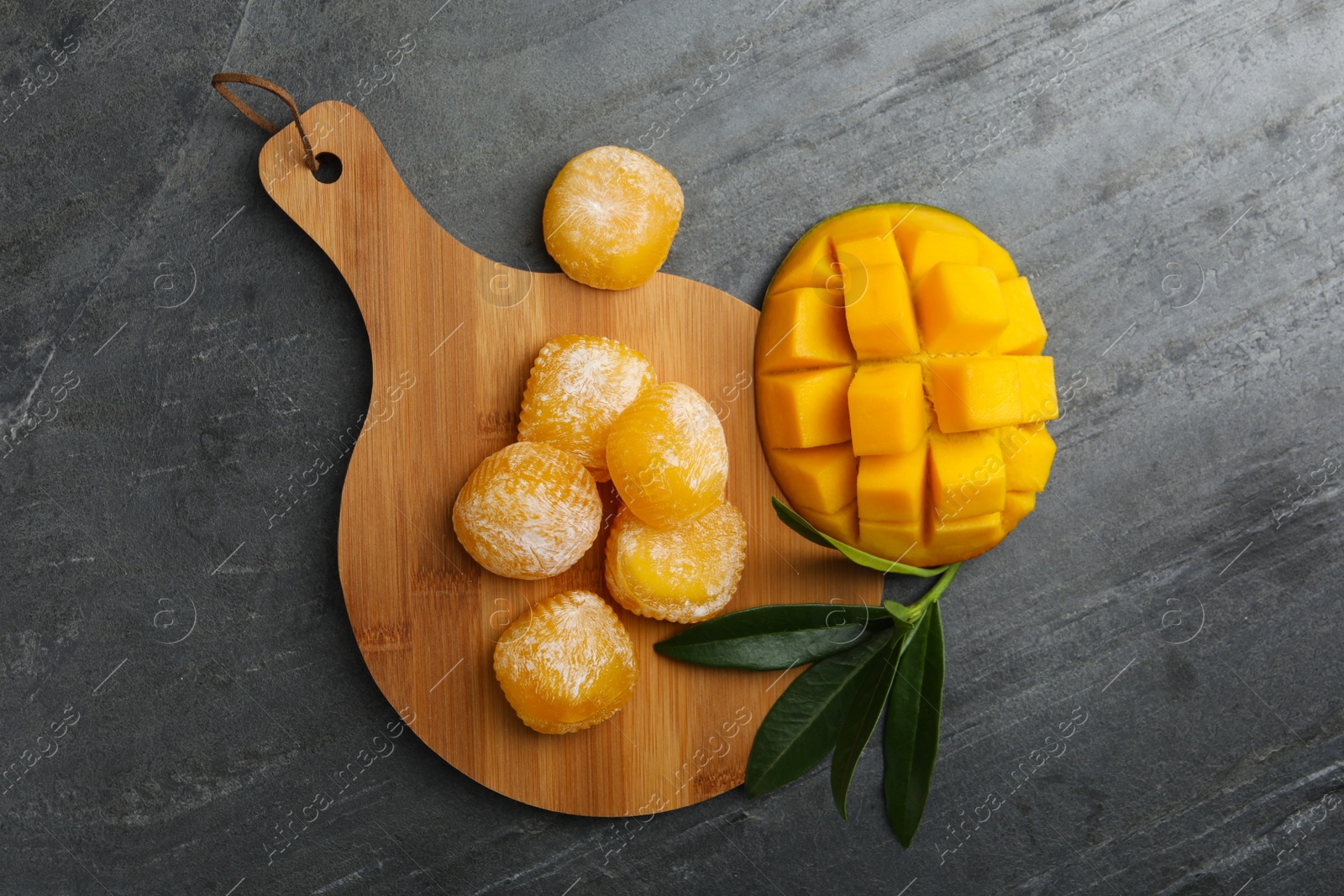 Photo of Delicious mango mochi on grey table, flat lay