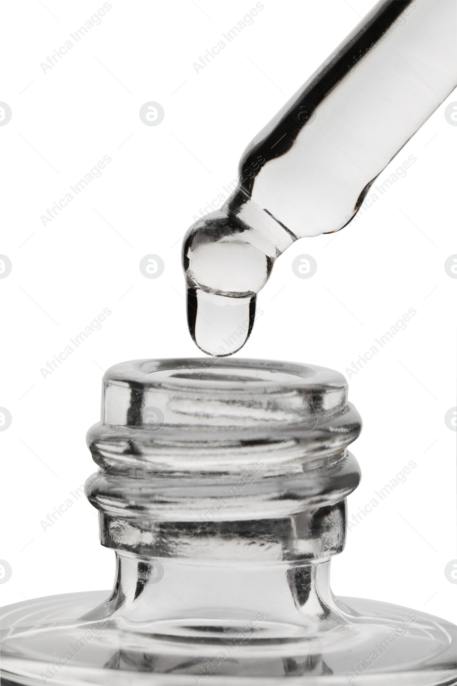 Photo of Dripping clear facial serum from pipette into glass bottle on white background, closeup