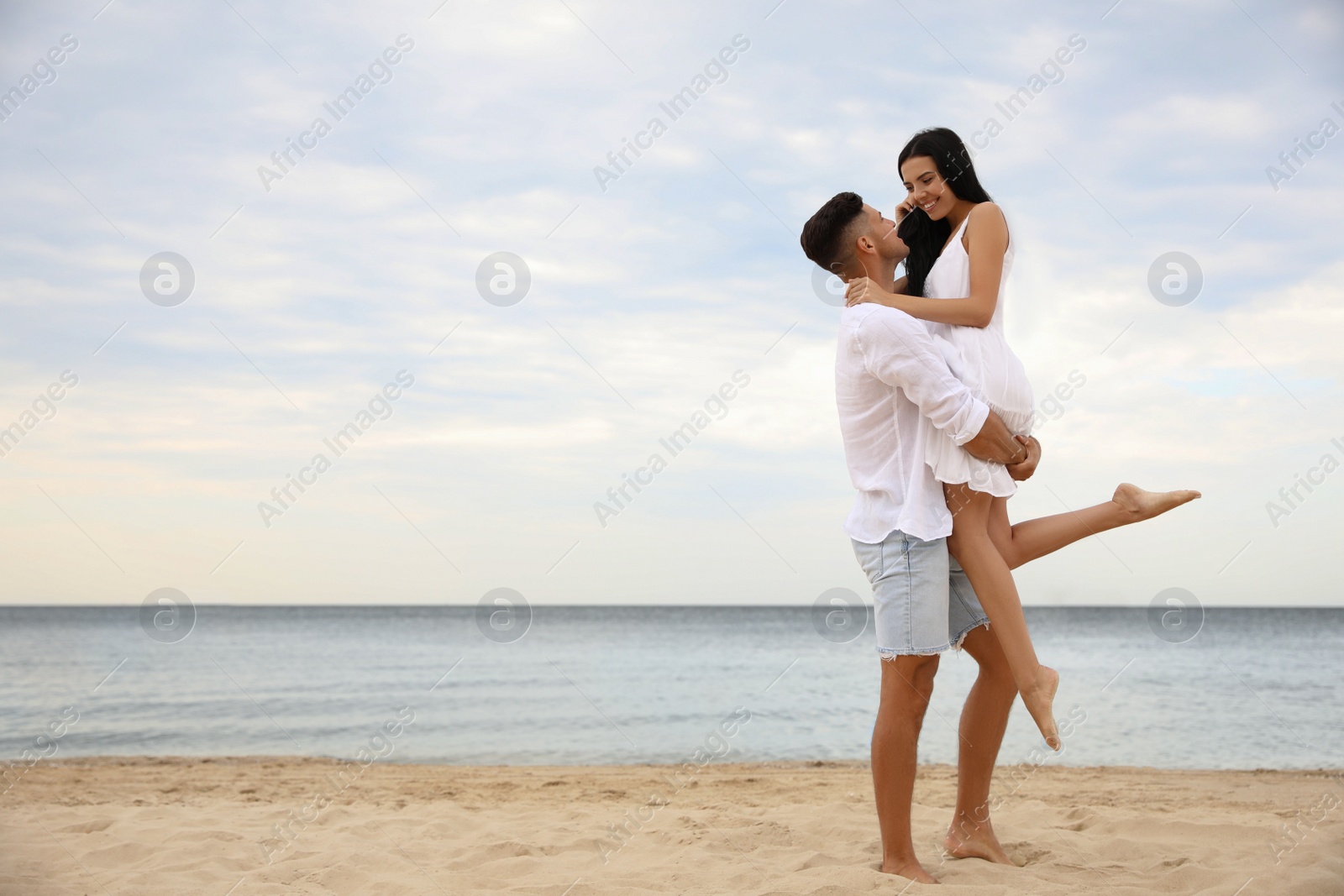 Photo of Lovely couple having fun on beautiful beach. Space for text