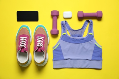 Photo of Stylish sportswear and equipment on yellow background, flat lay