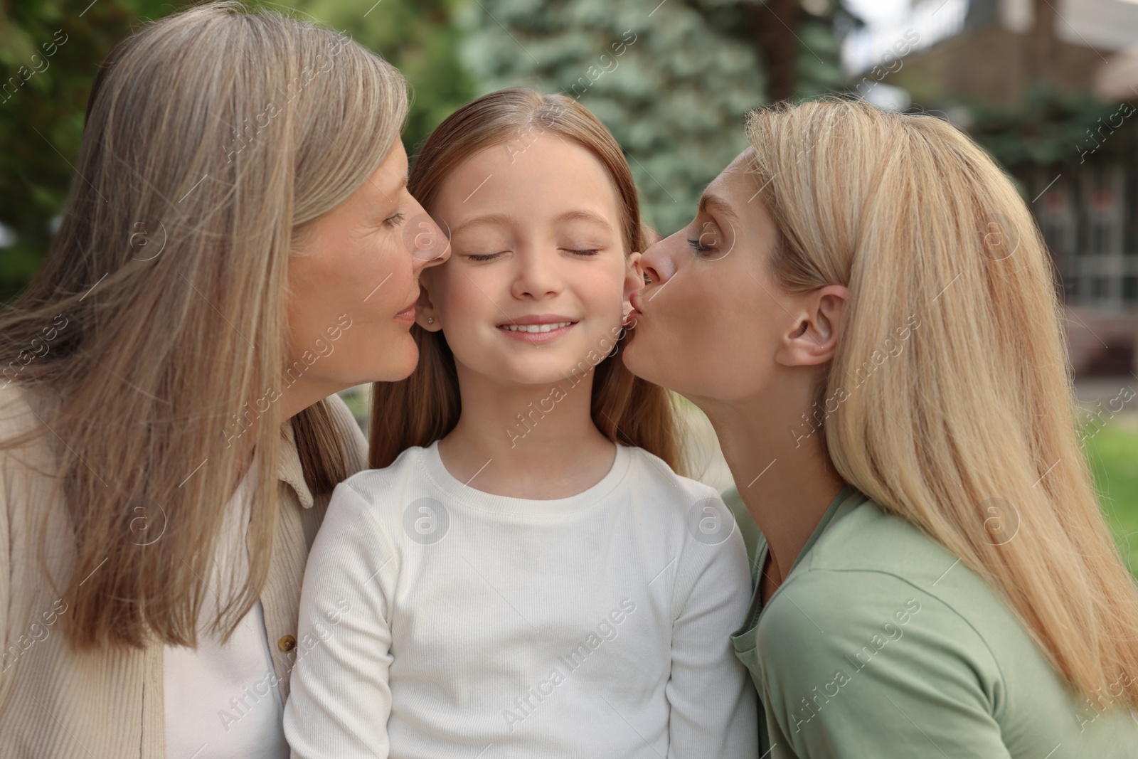 Photo of Three generations. Happy grandmother, her daughter and granddaughter outdoors