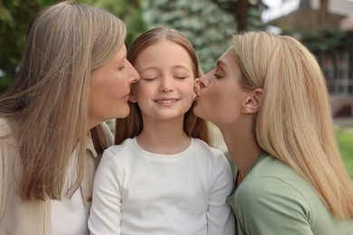 Photo of Three generations. Happy grandmother, her daughter and granddaughter outdoors