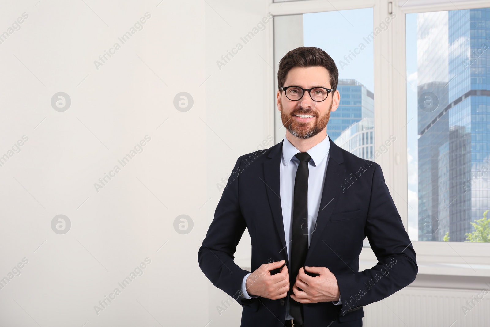Photo of Handsome real estate agent in nice suit indoors, space for text
