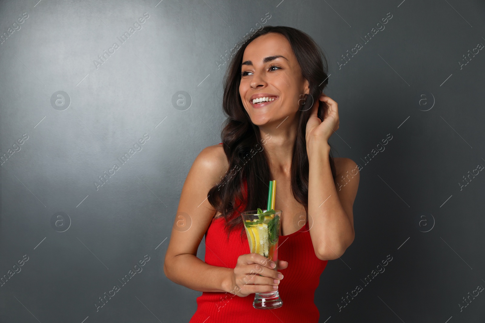 Photo of Young woman with refreshing drink on dark grey background