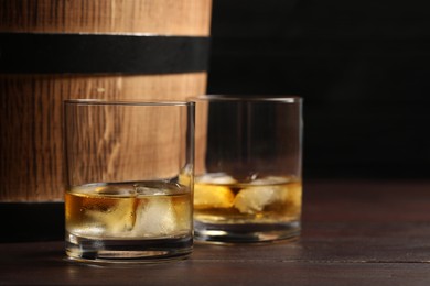 Photo of Tasty whiskey on wooden table, closeup. Space for text
