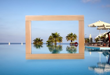 Image of Wooden frame and resort with swimming pool under blue sky