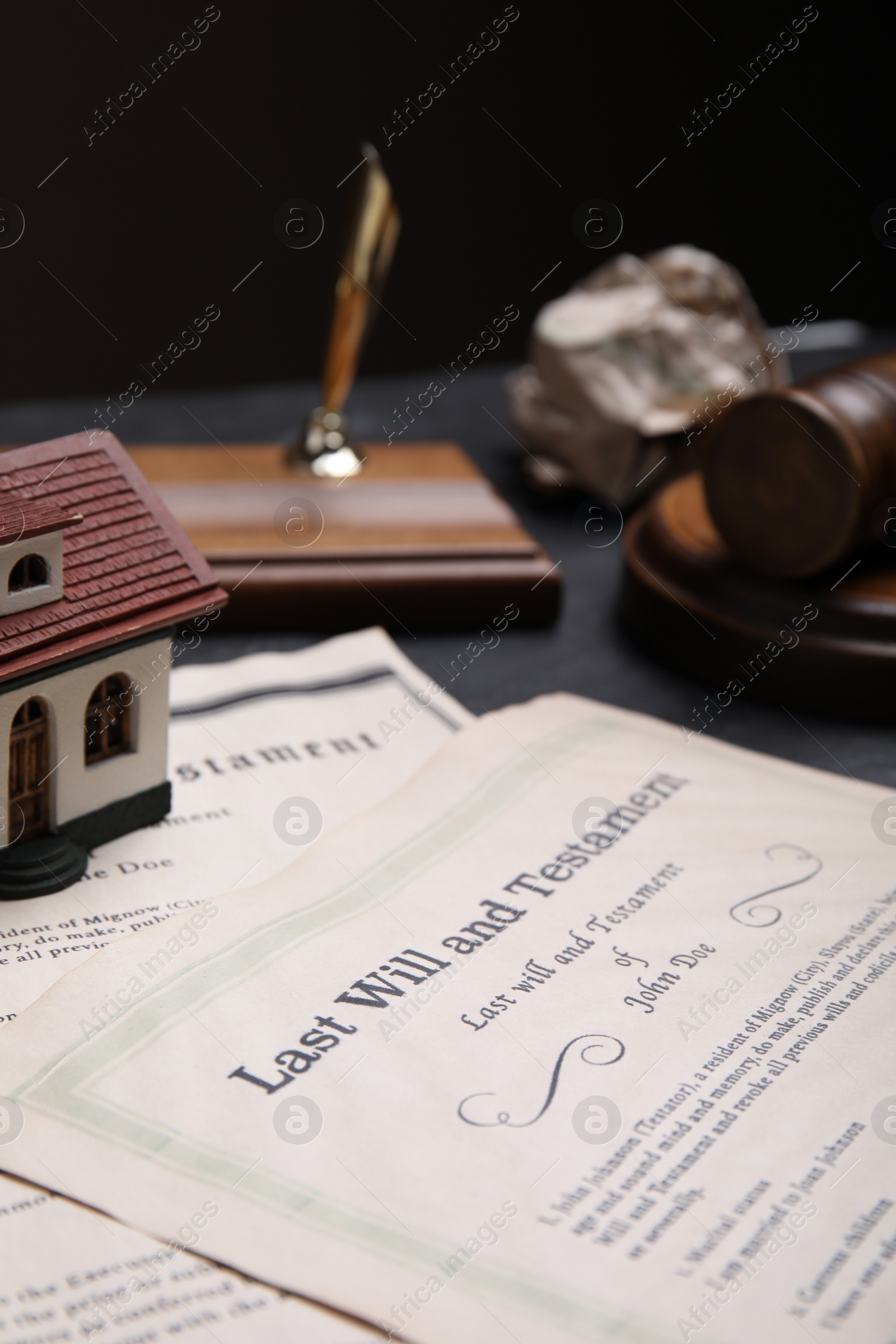 Photo of Last will and testament near house model on grey table, closeup