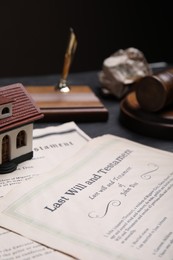 Photo of Last will and testament near house model on grey table, closeup