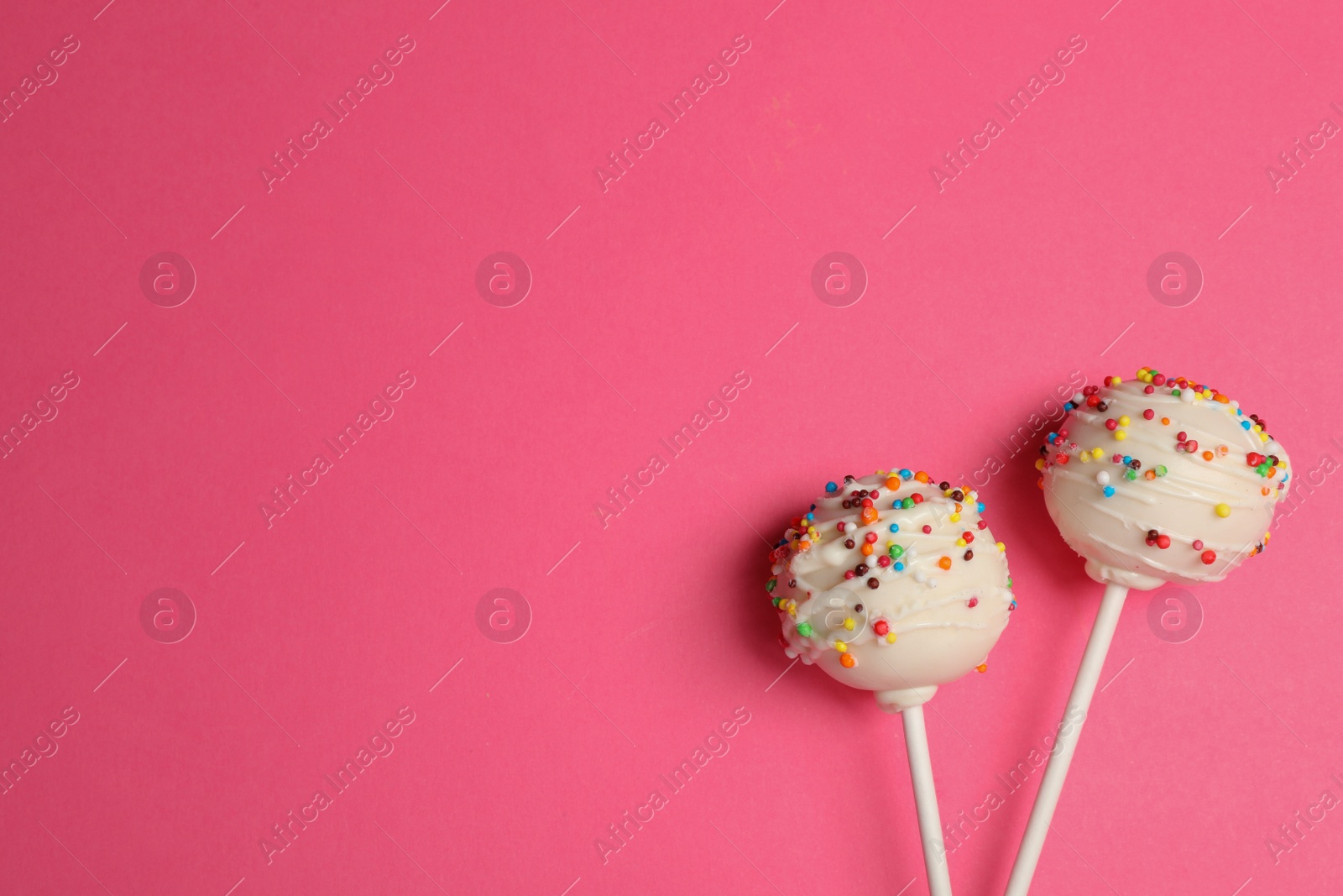 Photo of Bright delicious cake pops on color background, flat lay. Space for text